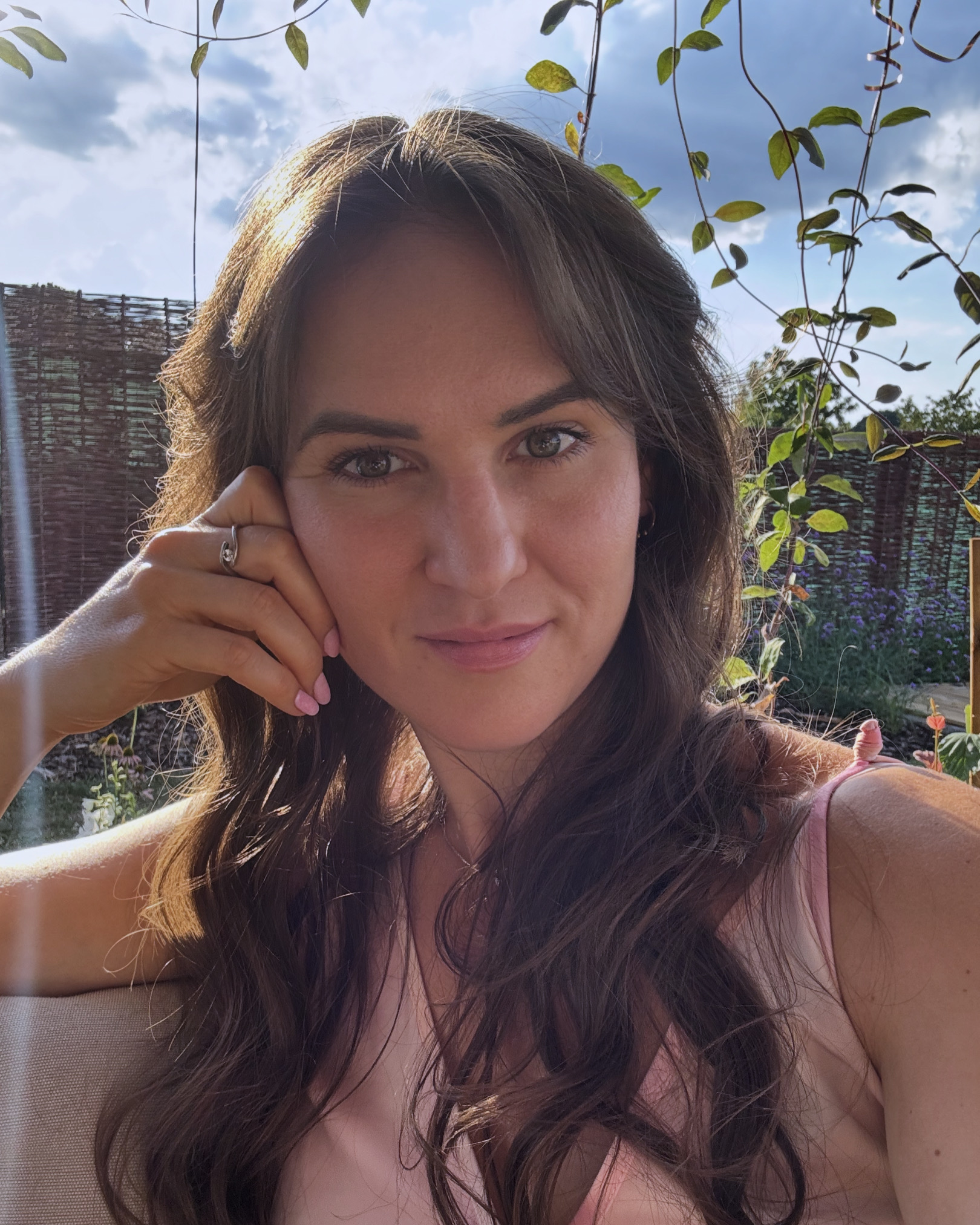Záhradníčka spokojne sedí vo svojej záhrade a užíva si slnko